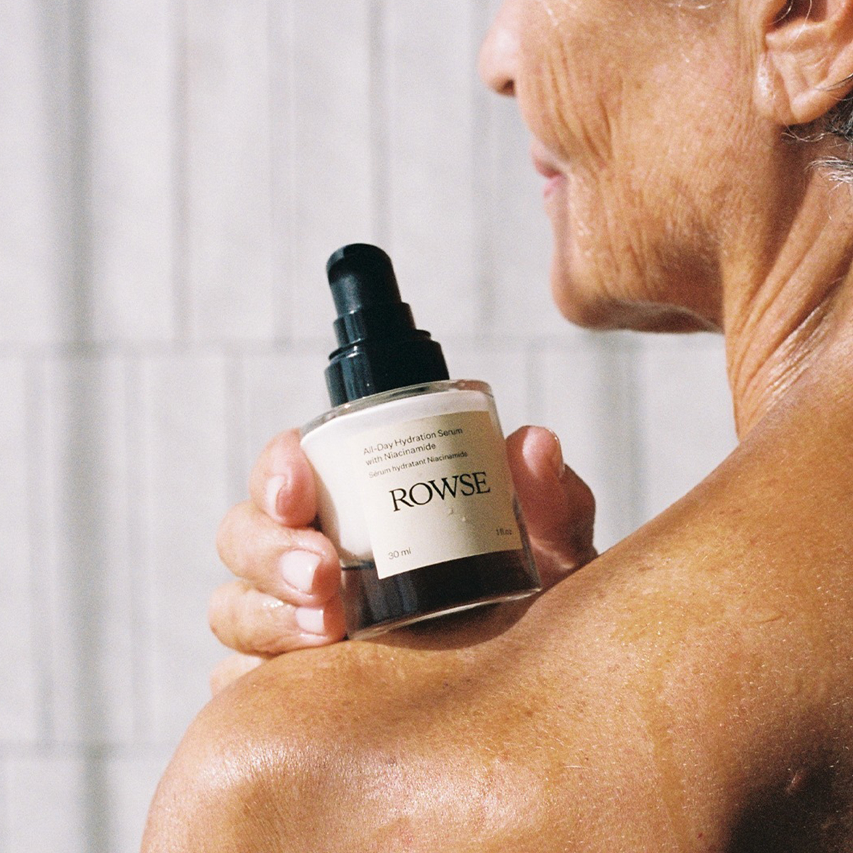 rowse beauty campaign image of a woman holding all day serum with niancinamide 